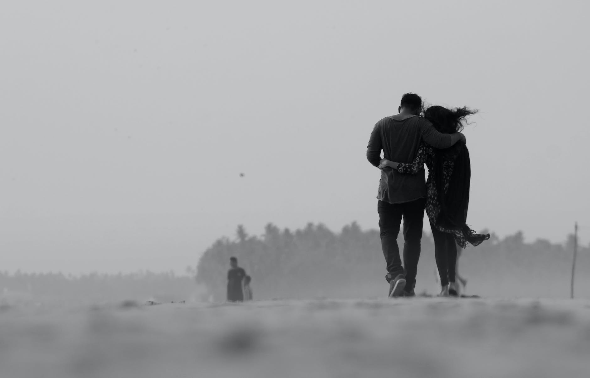 grayscale photography of couple walking on ground